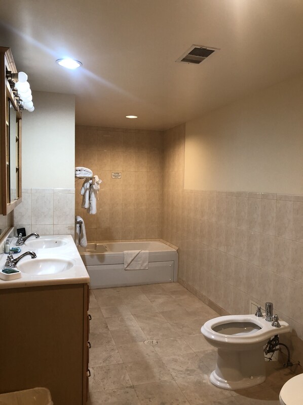 A bathroom with two sinks, a bathtub, and a toilet. - Mikado Hotel - Universal Studios/Burbank (Valley Village)