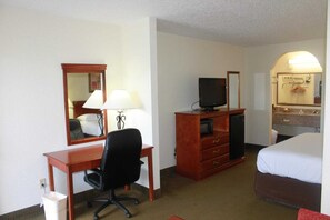 A hotel room with a desk, chair, television, bed, and a mirror. - Studio 6 Luling, LA (Luling)