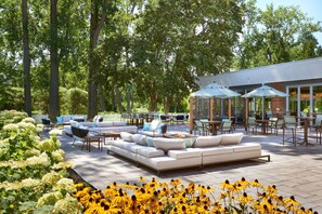 An outdoor patio area with a sofa, chairs, and umbrellas.