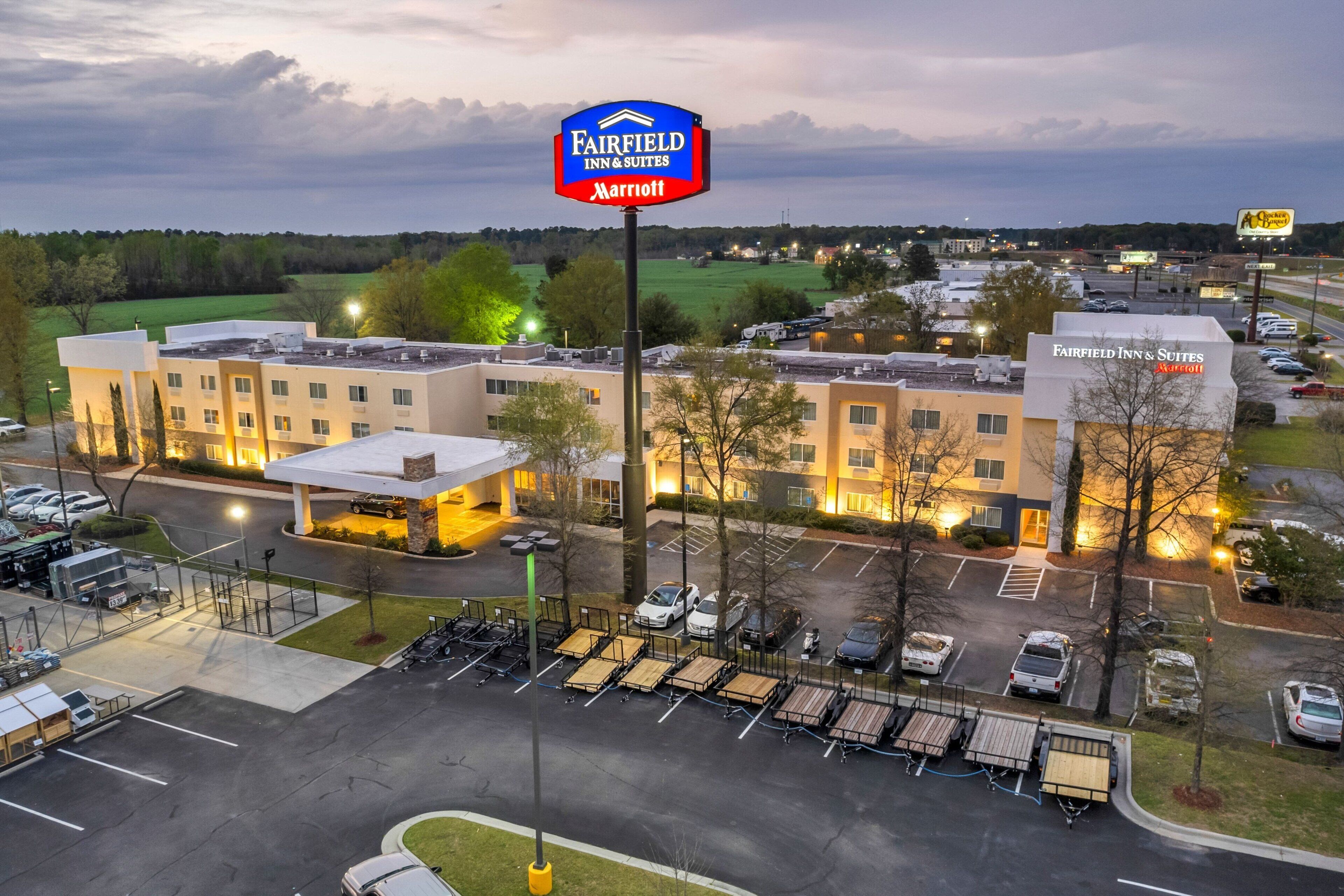 Un hotel Fairfield Inn & Suites Marriott con estacionamiento y edificios adyacentes.