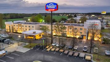 Un hotel Fairfield Inn & Suites Marriott con estacionamiento y edificios adyacentes.