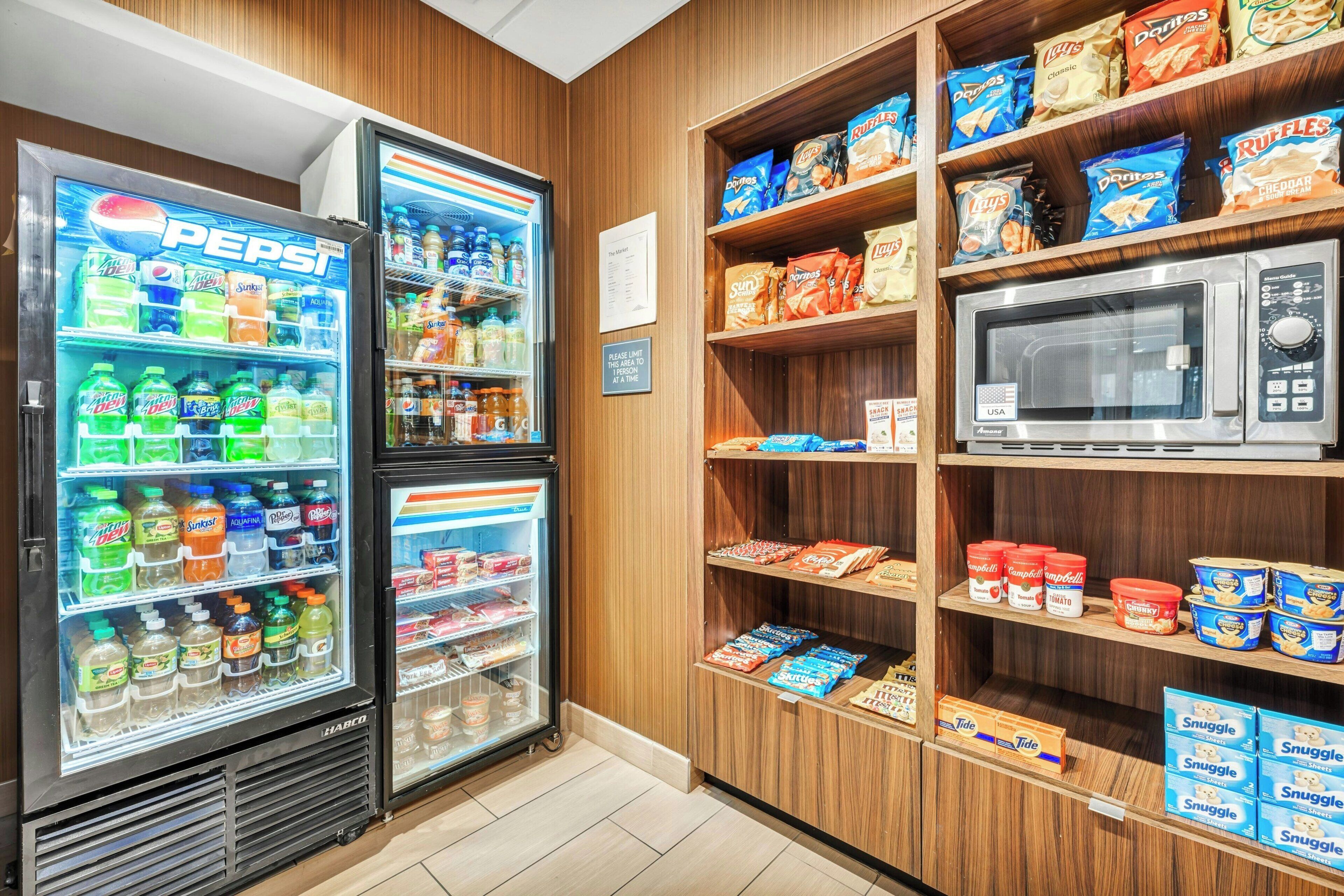 A vending area with Pepsi and Mountain Dew coolers, a microwave, and shelves stocked with snacks like Ruffles and Lay's.