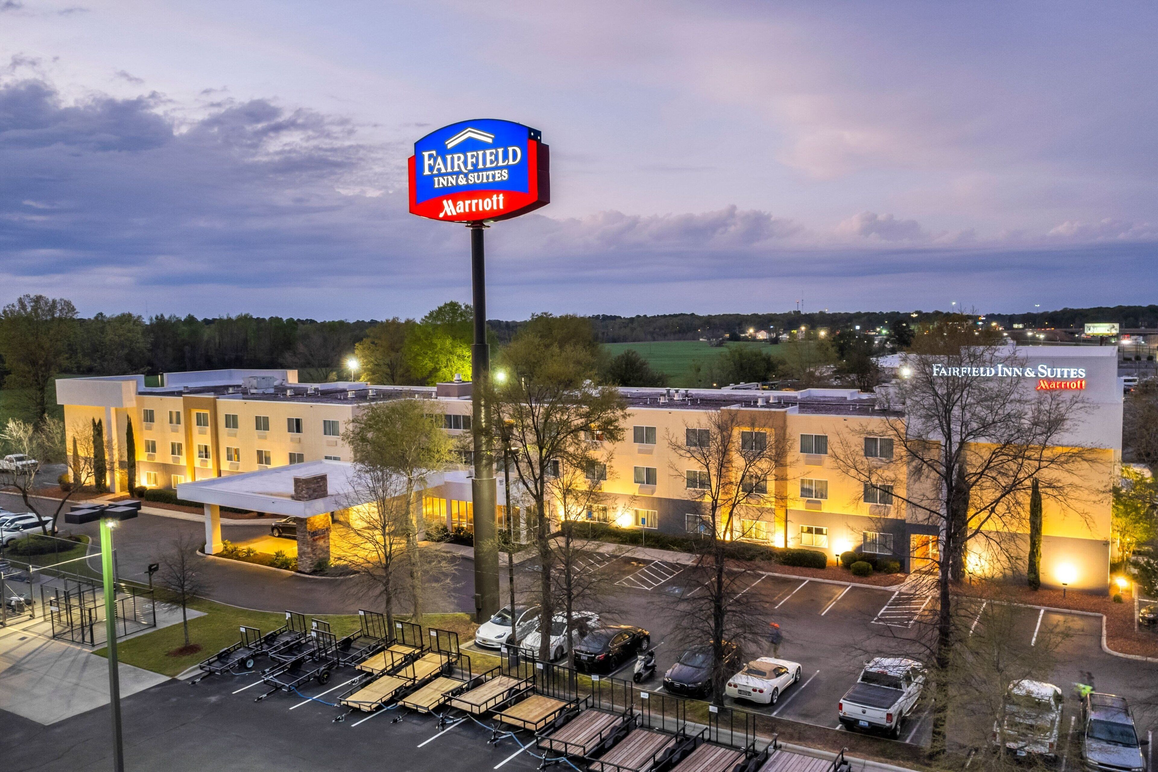 Un hotel Fairfield Inn & Suites Marriott con estacionamiento y un cartel grande.