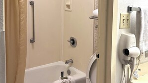 Ein Badezimmer mit Badewanne, Toilette und Duschbereich.