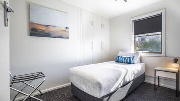 Un hotel moderno con una cama grande, un cuadro en la pared y una ventana con vistas.