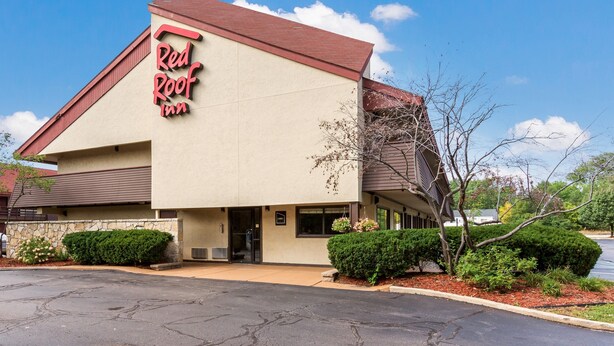 Un edificio con un letrero que dice 'Red Roof Inn' y fachada de piedra.