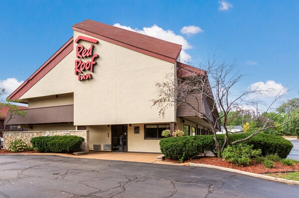 Un edificio con un letrero que dice 'Red Roof Inn' y fachada de piedra.