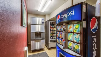 A vending machine area with a Pepsi machine and a refrigerator.