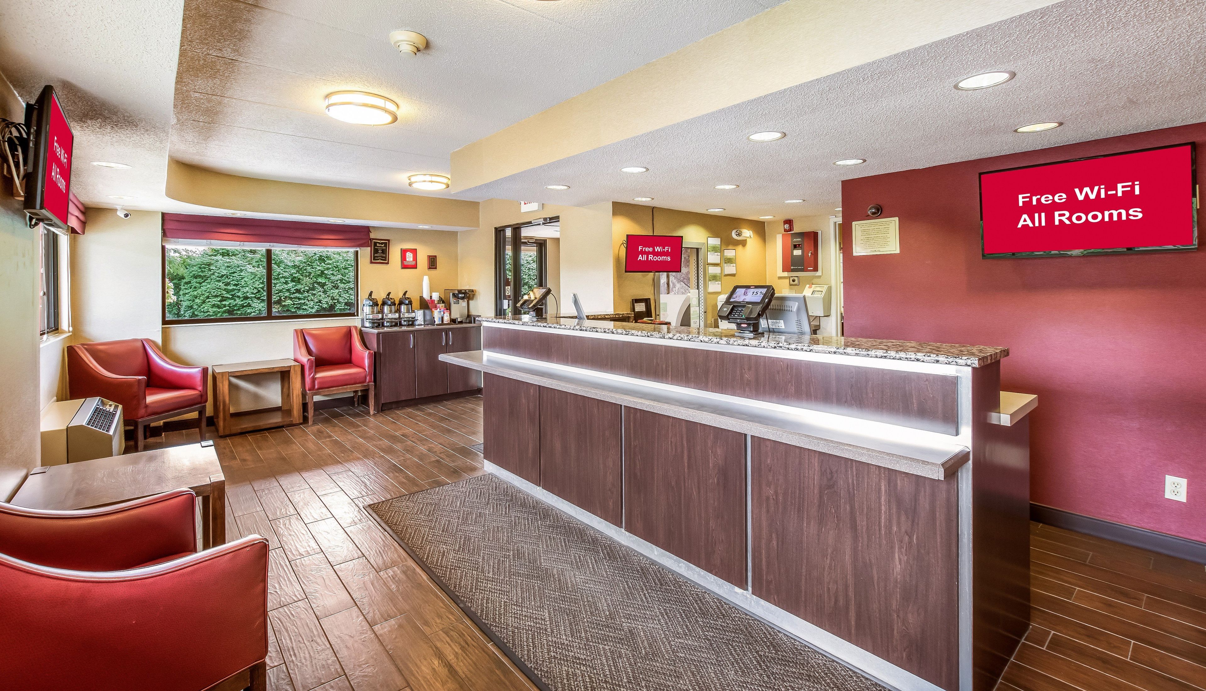A hotel reception area with a counter, seating, and a sign indicating free Wi-Fi availability.