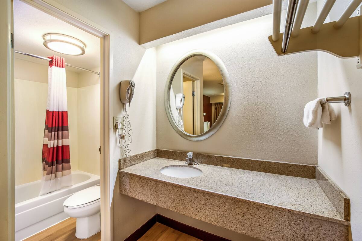 A bathroom with a sink, mirror, and toilet.