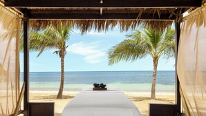 Ein Zimmer mit Blick auf den Strand, Palmen und den Ozean.