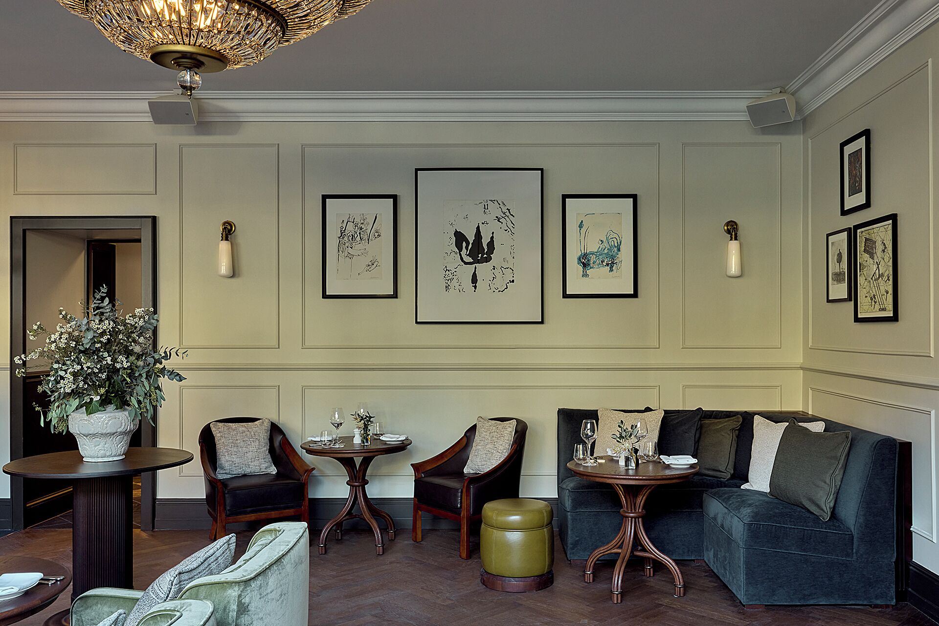 A well-appointed lounge area with a sofa, two armchairs, a small table, and a decorative vase.