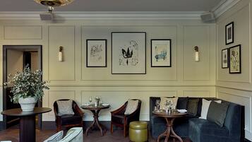 A well-appointed lounge area with a sofa, two armchairs, a small table, and a decorative vase.
