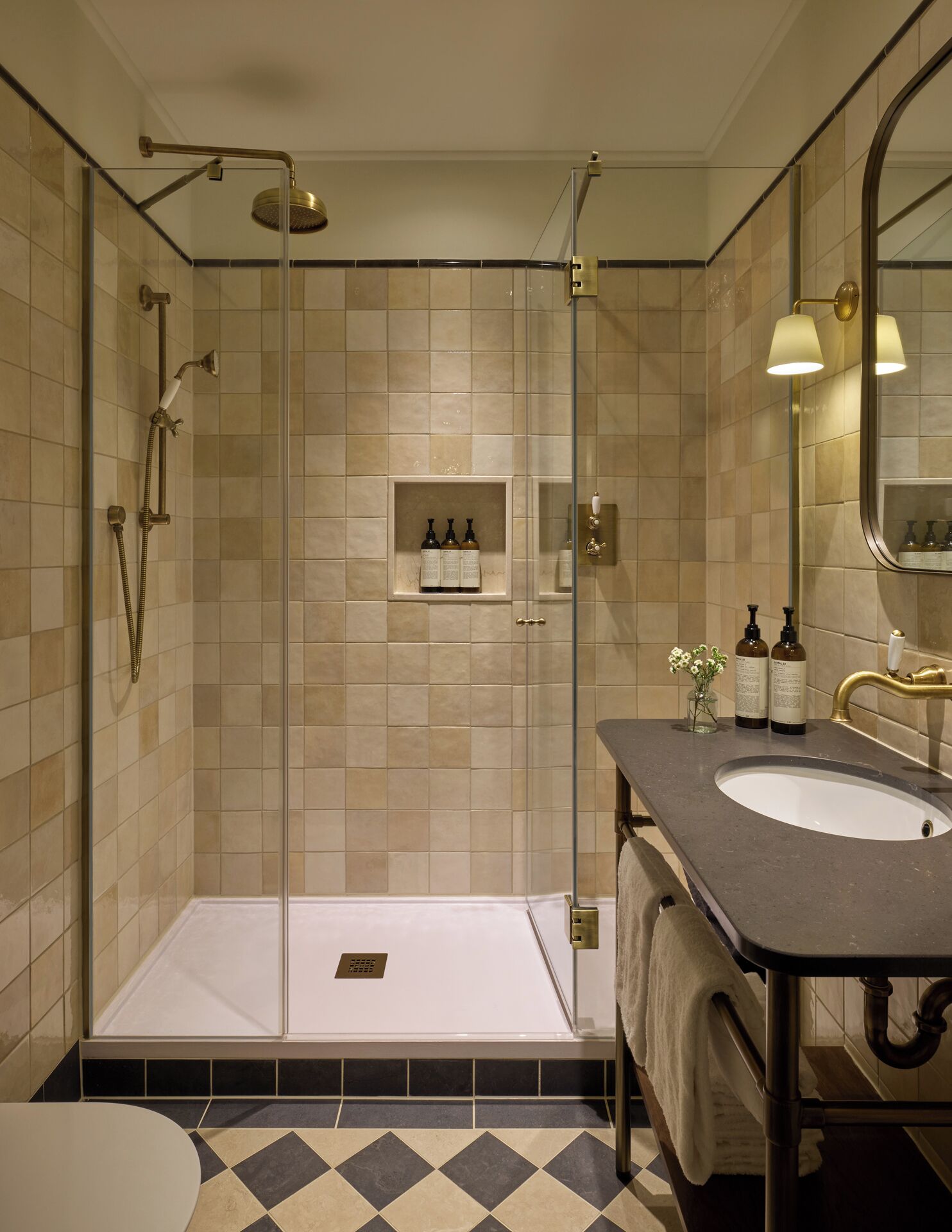 Een moderne badkamer met een douchecabine van glas, een wastafelmeubel en een spiegel.