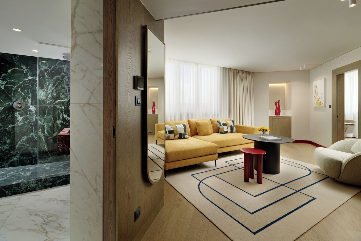 A modern living room with a sofa, a coffee table, and a mirror.