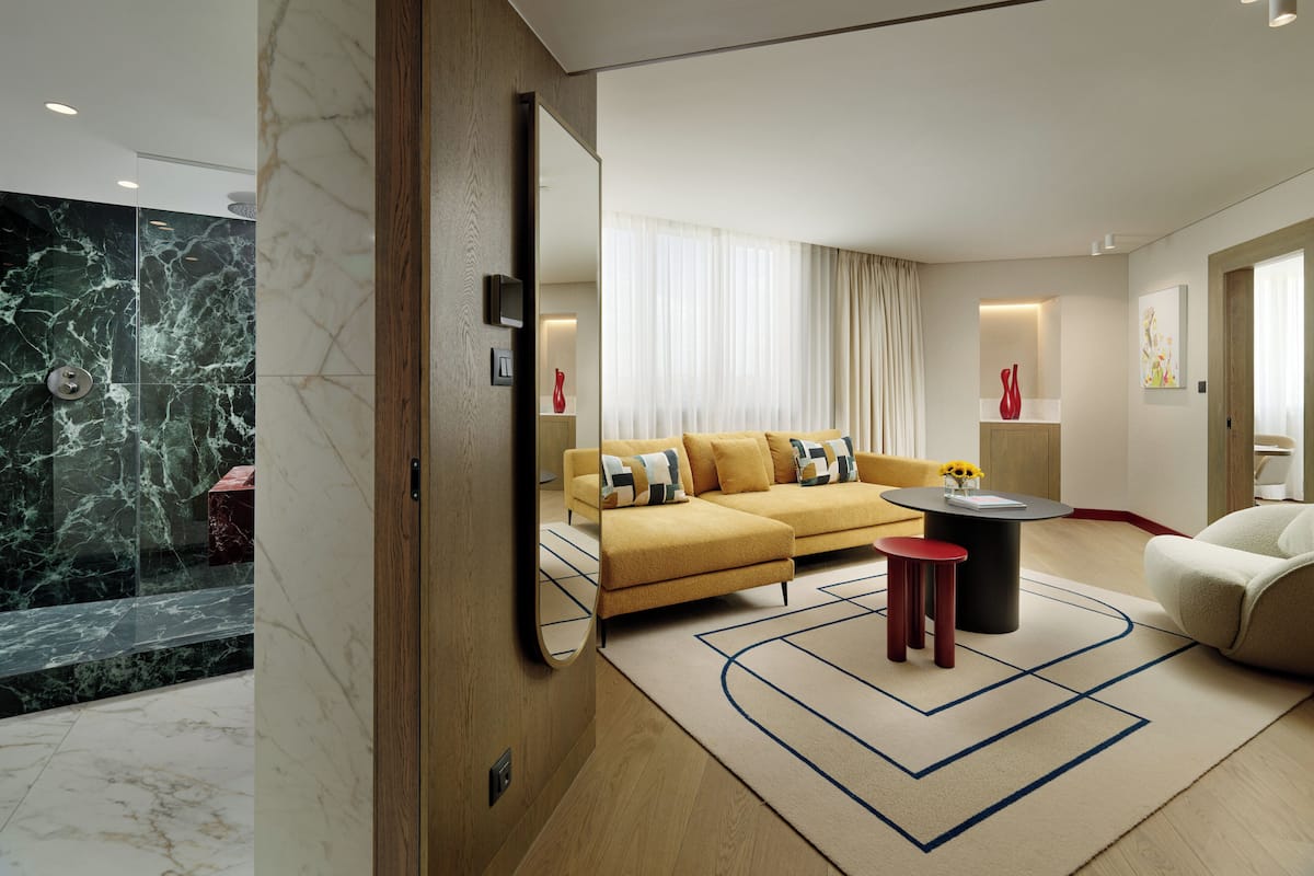 A modern living room with a sofa, a coffee table, and a mirror.