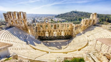 Un antiguo anfiteatro con gradas escalonadas y ruinas de piedra.