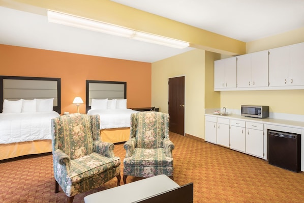 Quarto de hotel com duas camas, uma escrivaninha, uma cadeira, micro-ondas e máquina de lavar louça.