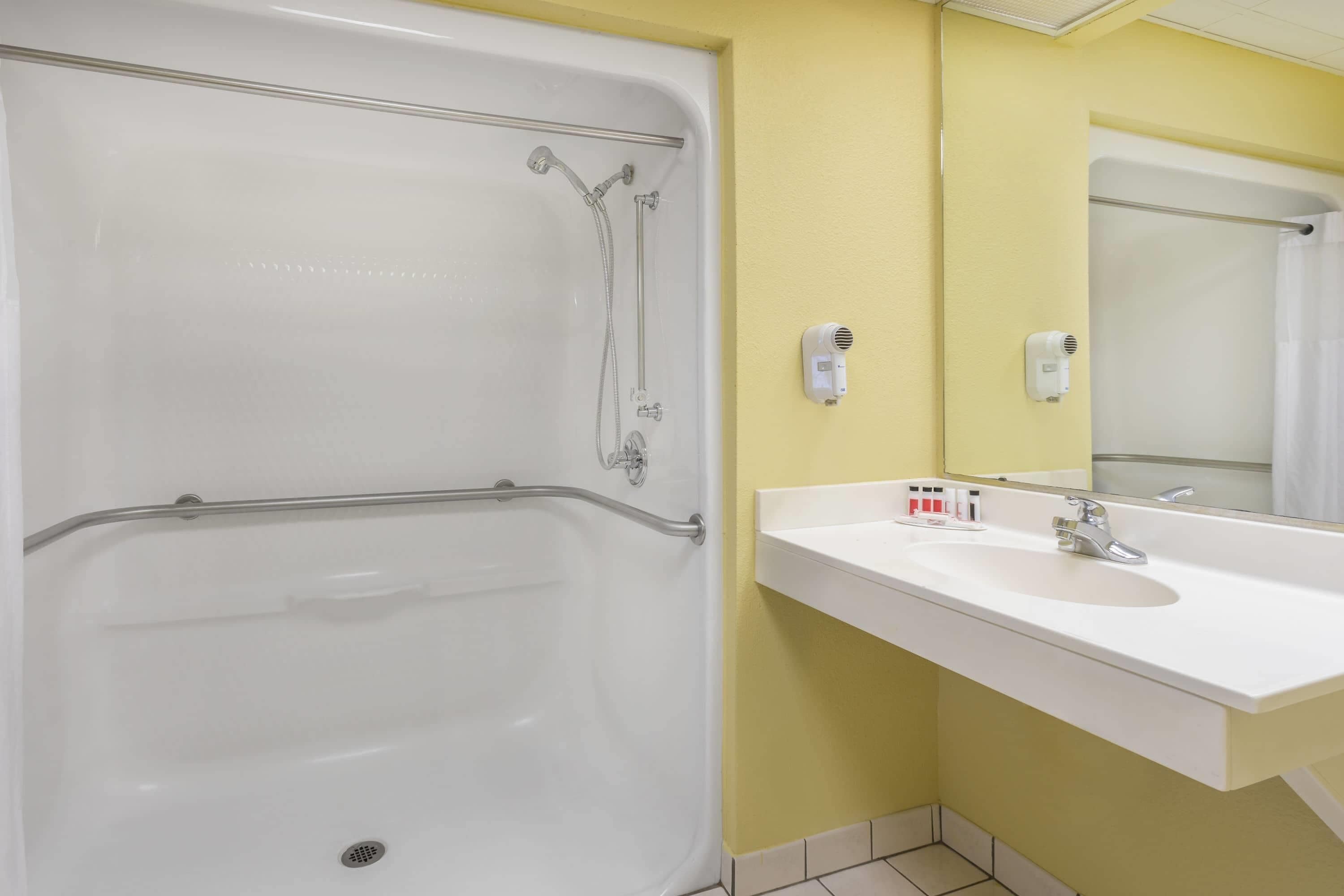 Un baño con bañera, lavabo y espejo.