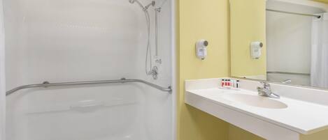 A bathroom with a bathtub, a sink, and a mirror.
