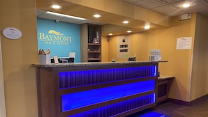 Un área de recepción con pared azul, una computadora Dell y un cartel que indica que el lobby es para no fumadores.