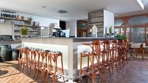 A modern bar area with wooden flooring, multiple bar stools, and a variety of bar tools and bottles. - ACHAT Hotel Neustadt an der Weinstraße (Neustadt an der Weinstrasse)