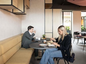 A modern interior with a round table, a sofa, and a potted plant. - ibis Antwerpen Centrum (Antwerp)