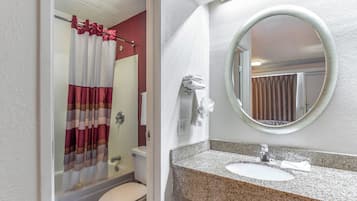 Un baño con cortina de ducha, inodoro, lavabo y espejo.