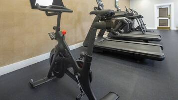 Un gimnasio con bicicletas estáticas y cintas de correr.