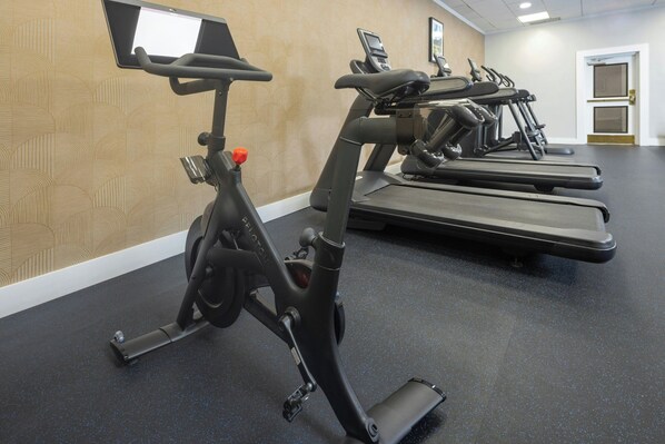 Une salle de sport équipée de vélos d'exercice et de tapis de course.