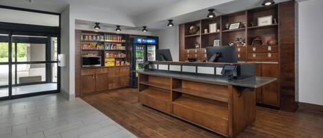 A reception area with a counter, a Pepsi refrigerator, and a variety of snacks.
