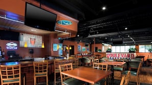 A restaurant interior with wooden tables and chairs, a bar area, and a large 'Boulevard' sign. - Four Points by Sheraton Kansas City Airport (Kansas City)