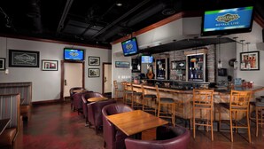A bar area with multiple seating options, including bar stools and booths, and a television displaying 'Boulevard' branding. - Four Points by Sheraton Kansas City Airport (Kansas City)