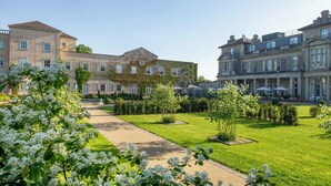 A courtyard with a pathway, surrounded by well-maintained lawns and flowering trees.