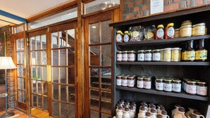 A store interior with glass doors leading to a balcony, shelves stocked with jars of honey and maple syrup, and a box of chocolate bars on a table. - Fireside Inn & Suites Waterville (Waterville)