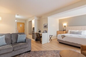 A hotel room with a bed, a sofa, a desk, and a chair. - Fireside Inn & Suites Waterville (Waterville)