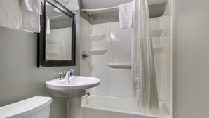 A bathroom with a white sink, a toilet, and a bathtub with a shower curtain.
