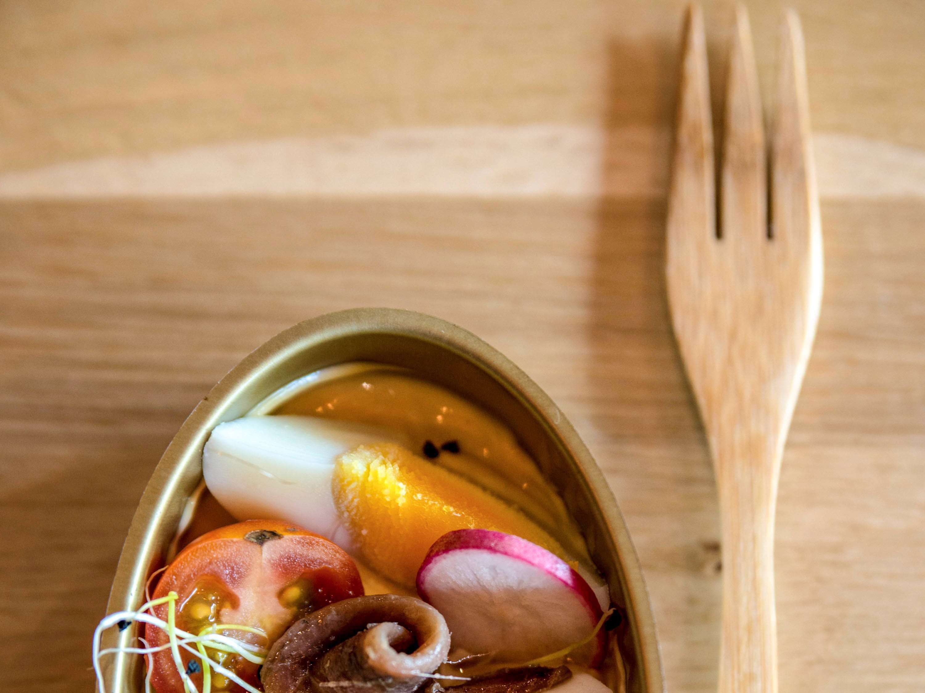 A bowl of assorted fruits and vegetables on a wooden table.