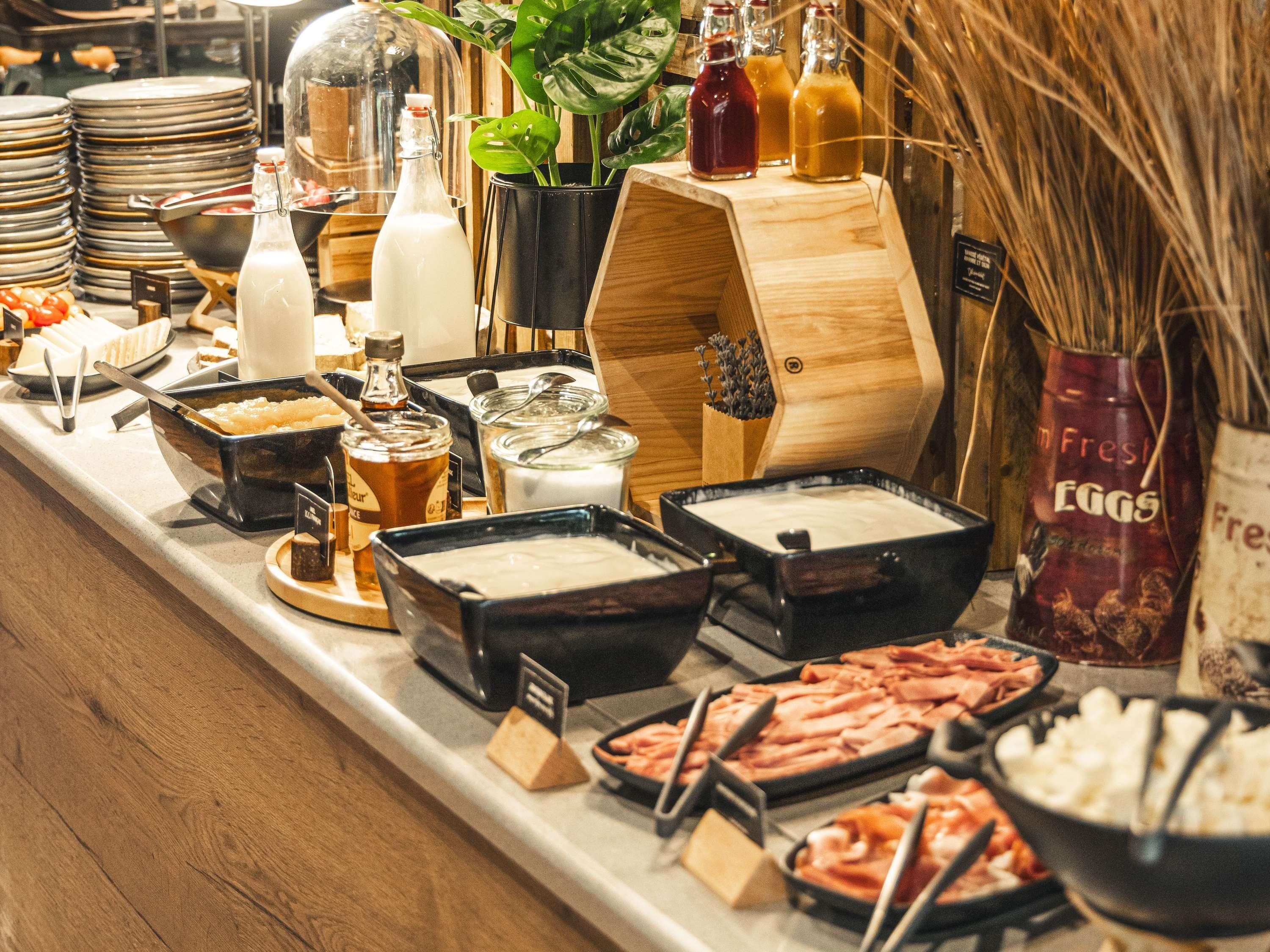A buffet setup with various food items and condiments.