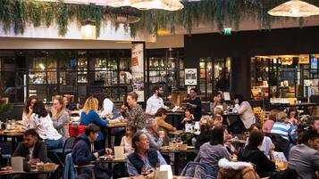 A bustling restaurant with multiple tables and patrons.