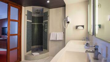 A modern bathroom with a walk-in shower, a large bathtub, and a vanity with a mirror.