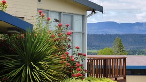 Uma casa com uma janela ampla que dá para uma paisagem montanhosa.