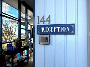 A reception sign with the number 144 and the word 'RECEPTION' on a white wall.