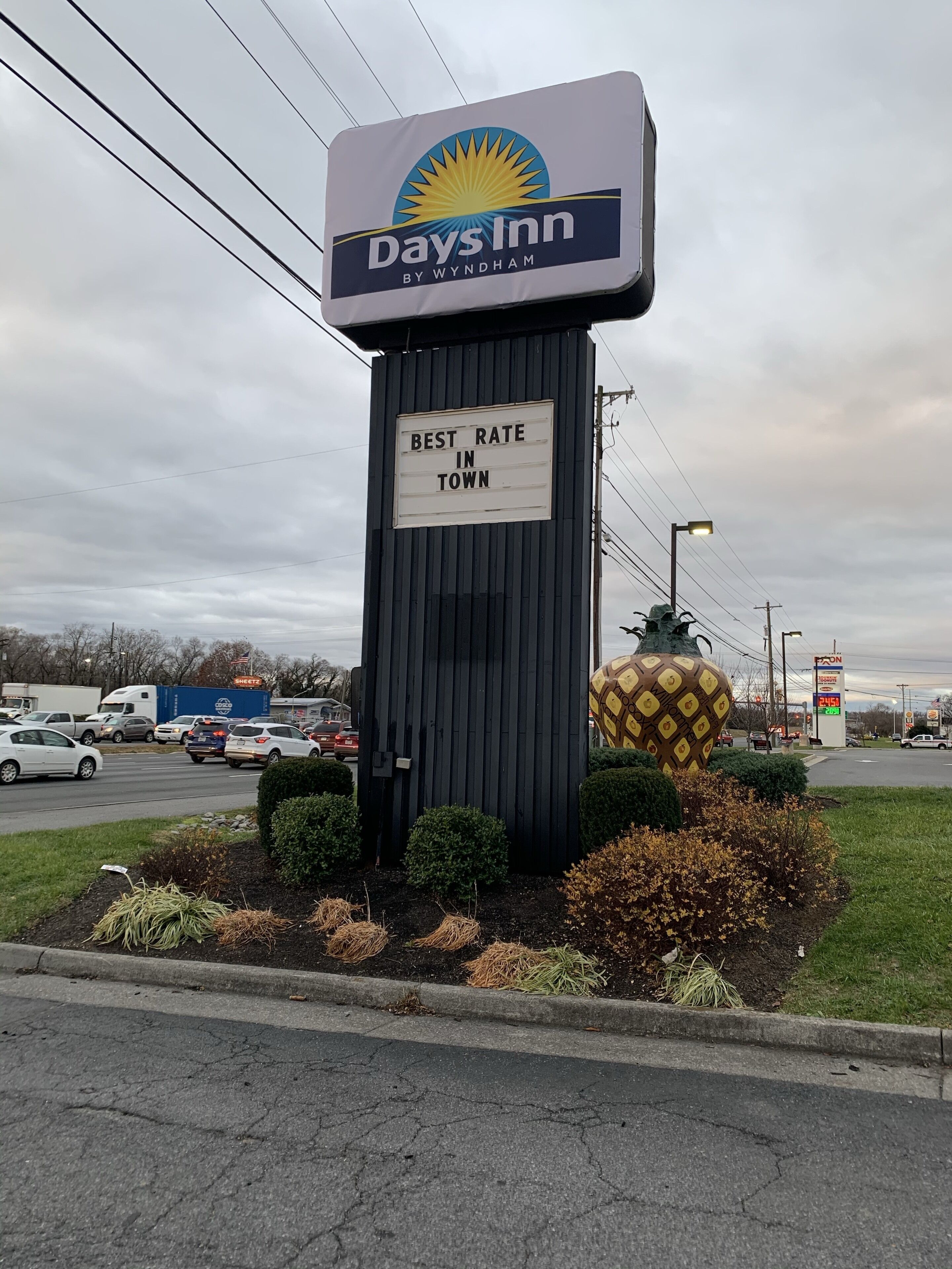 Skilt for Days Inn med beskeden 'Bedste pris i byen', omgivet af beplantning og en parkeringsplads.