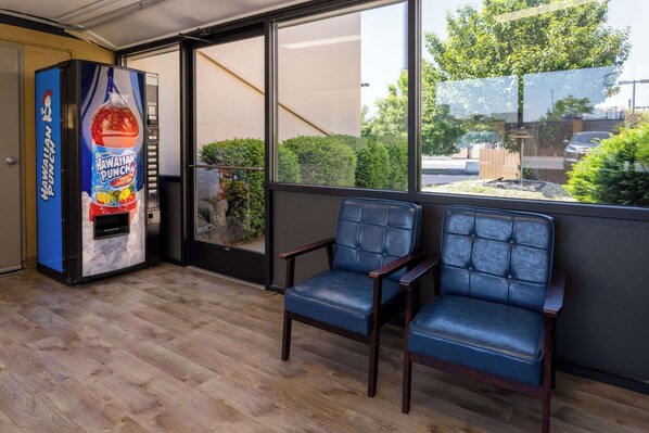 Un espace détente avec deux fauteuils en cuir bleu et un distributeur de boissons.