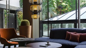 Un área de estar moderna con un sofá, sillones y una mesa de centro.