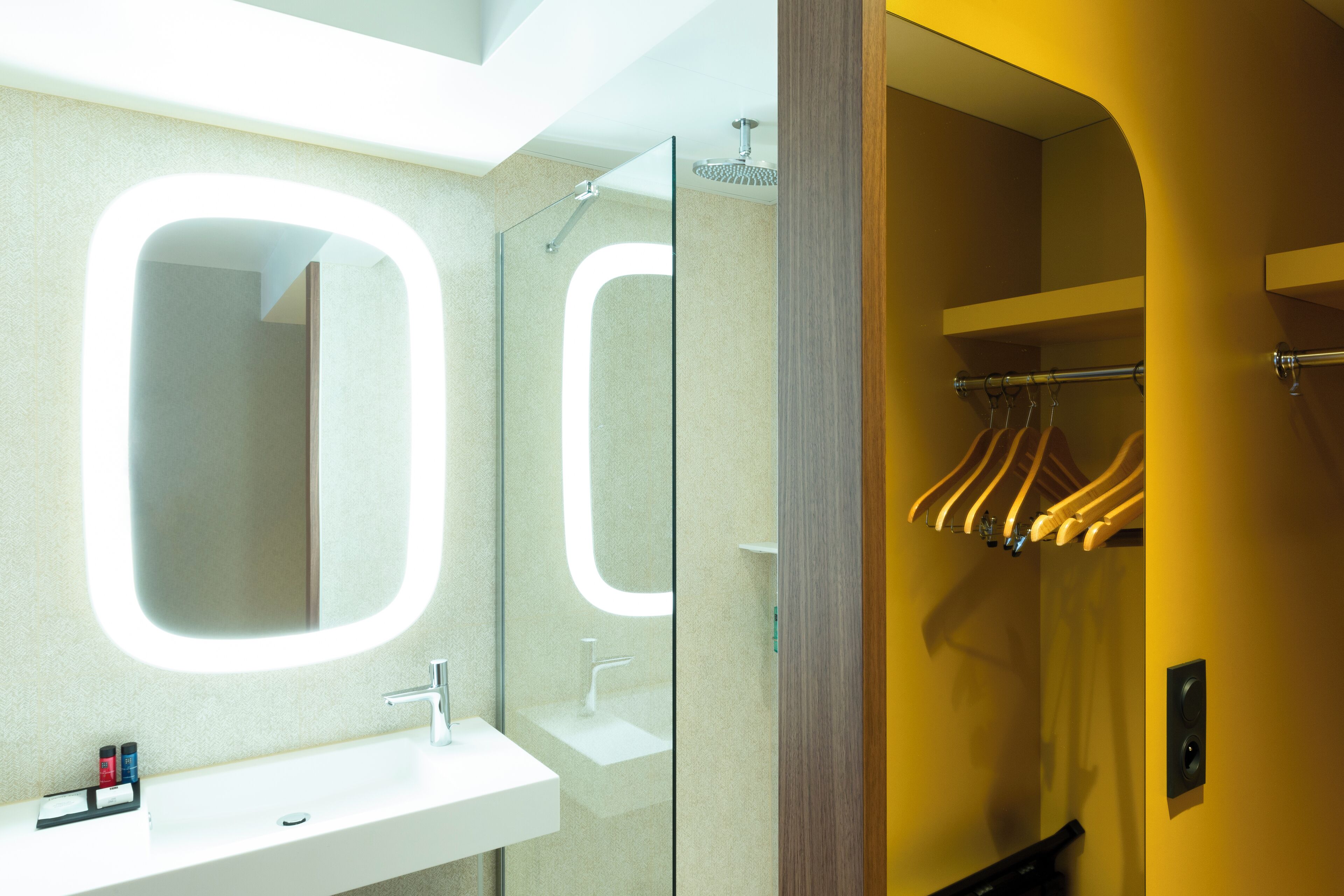 A bathroom with a white sink, a mirror, and a shower.