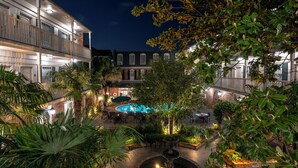 A courtyard with a swimming pool, outdoor seating, and a fountain.