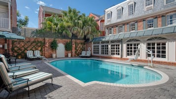 Alberca al aire libre, sombrillas en la alberca y camastros