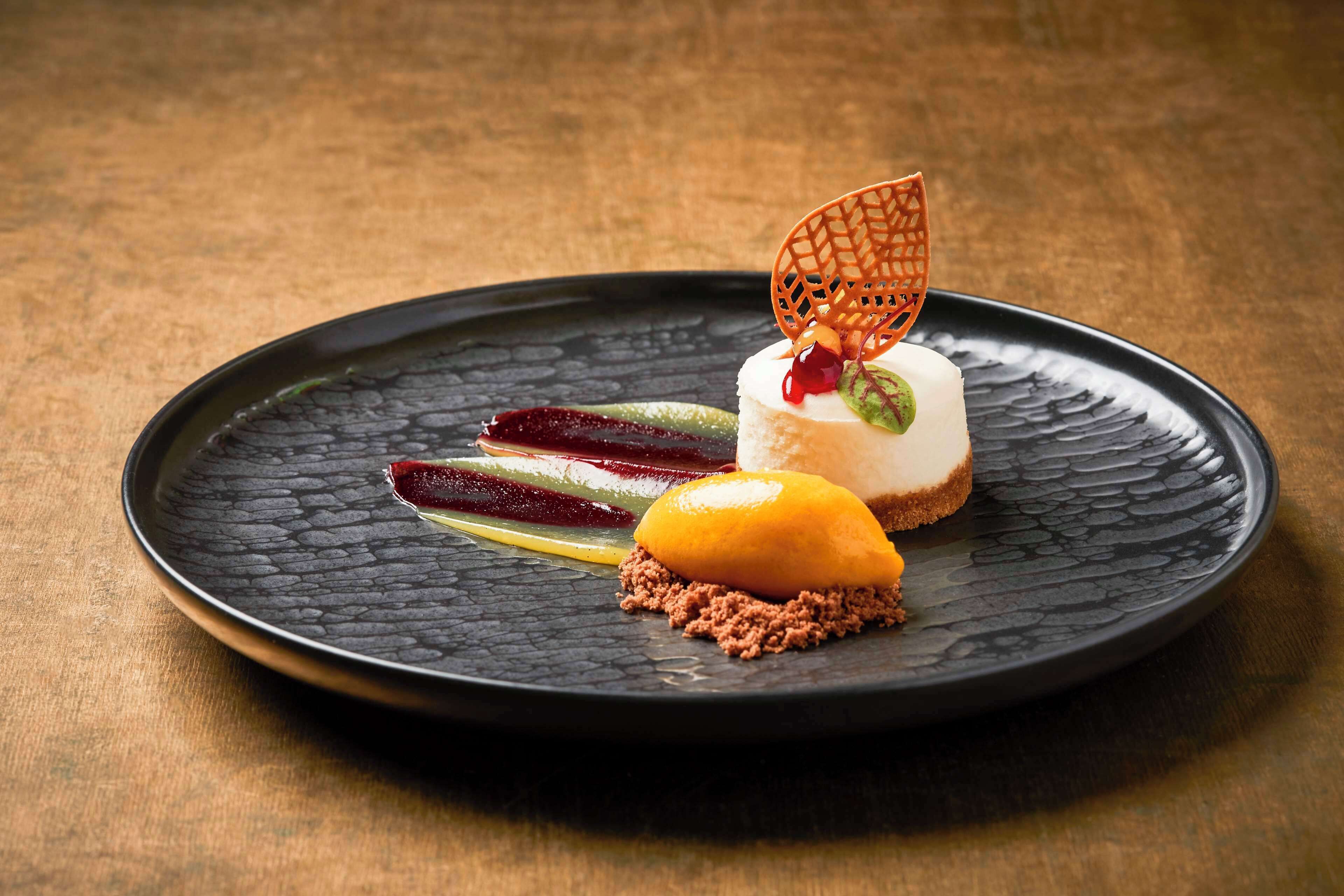 Een dessert op een zwart bord met een structuur, met een houten achtergrond.
